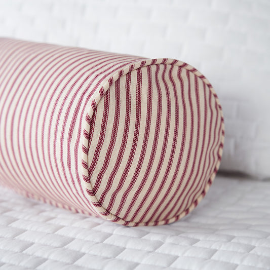 red ticking stripe bolster pillow on bed