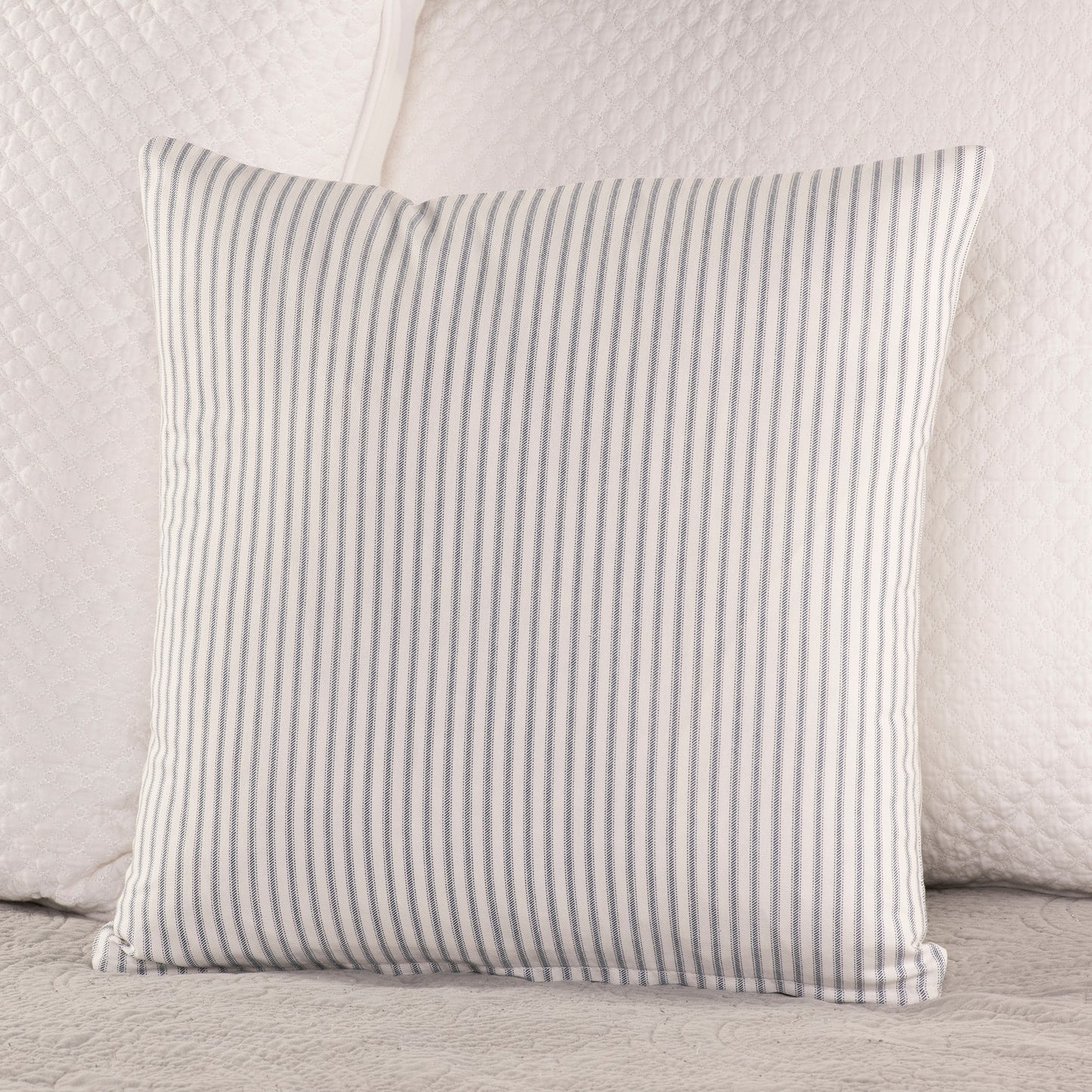 navy blue and white ticking stripe throw pillow on bed